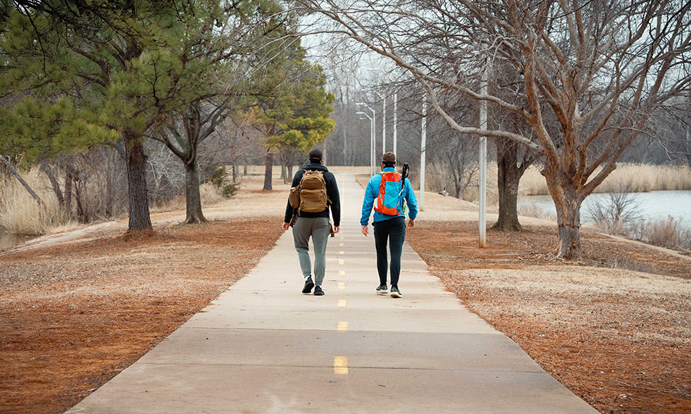 Bryson Wolfe and Ben Simpson, their backs to the camera, walk around Boomer Lake.