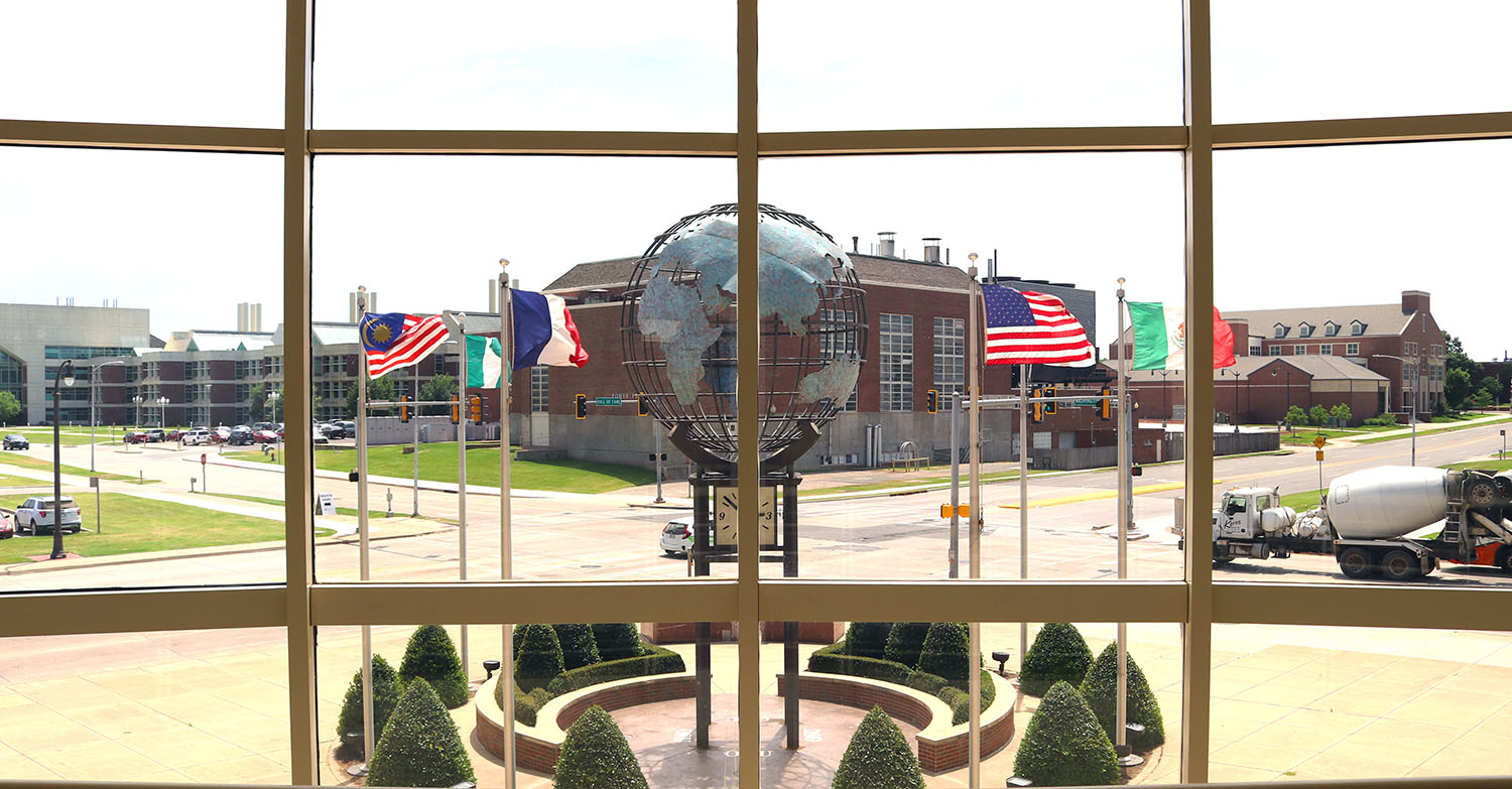 Looking out wes watkins window at globe statue and flags