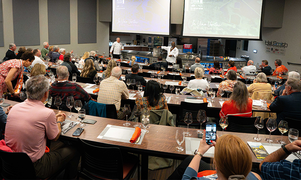 Chef Andrew Black at the front of a packed room as he speaks about food-wine pairings.
