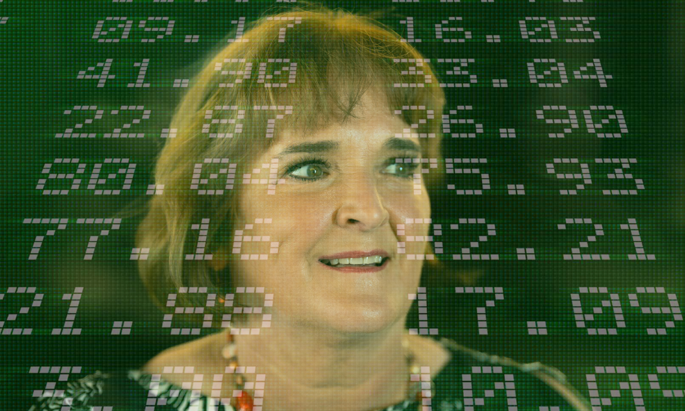 Dr. Betty Simkins smiles for a photo with stock market numbers superimposed in the background.