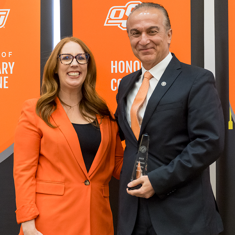 Dr. Dursun Delen holds his Eminent Faculty Award plaque and stands next to Dr. Jeanette Mendez.