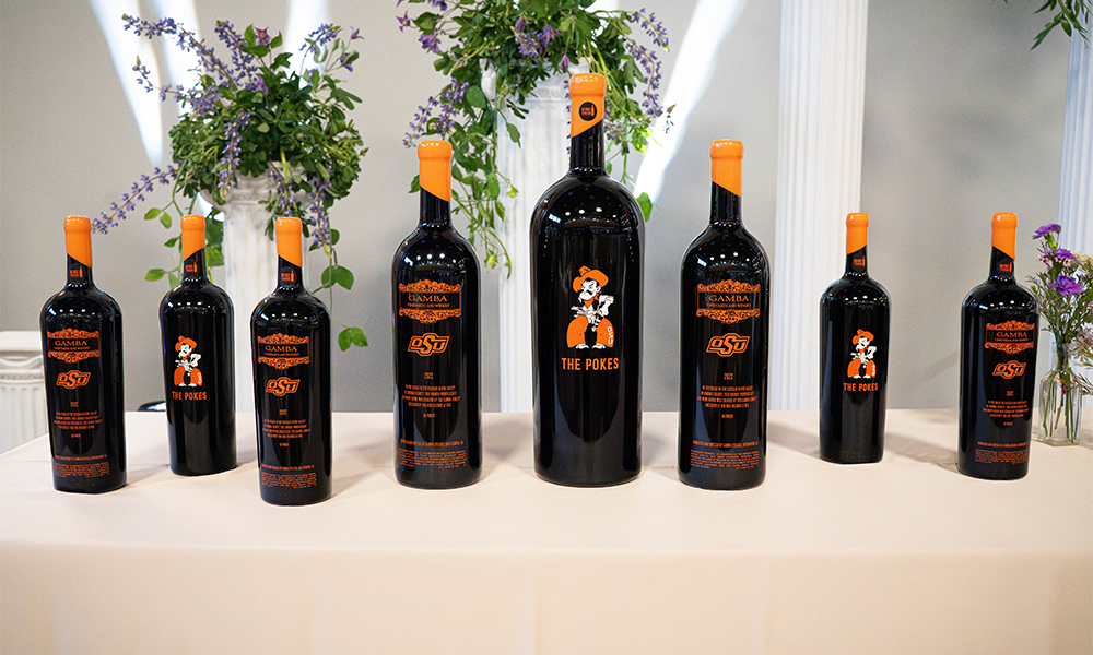 OSU themed wine bottles from Gamba Family Vinyards lined up on a table.