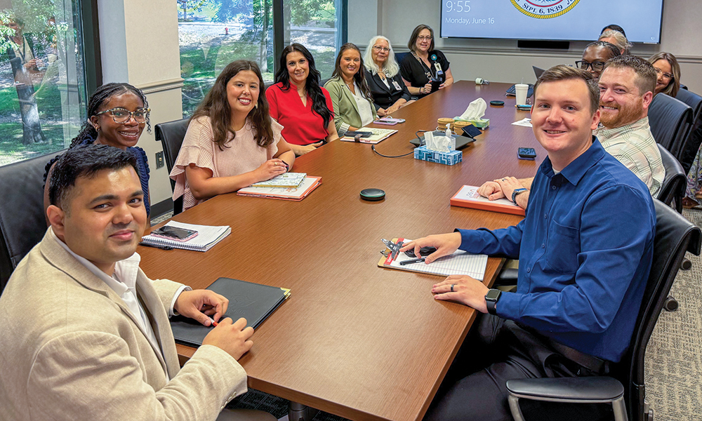 Lean Health Care interns sit around a boardroom table.