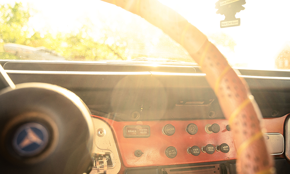 The sun glimmering through the steering wheel of West's Land Cruiser.