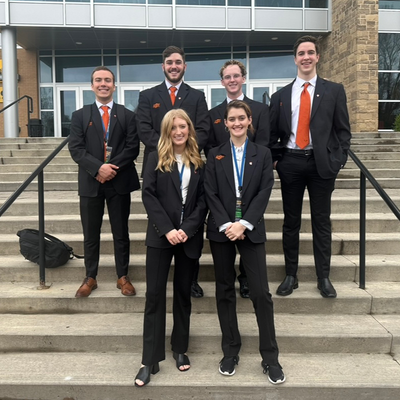 Members of the OSU Competitive Sales Team pose on the steps of a building after a sales competition at Kennessaw State University.