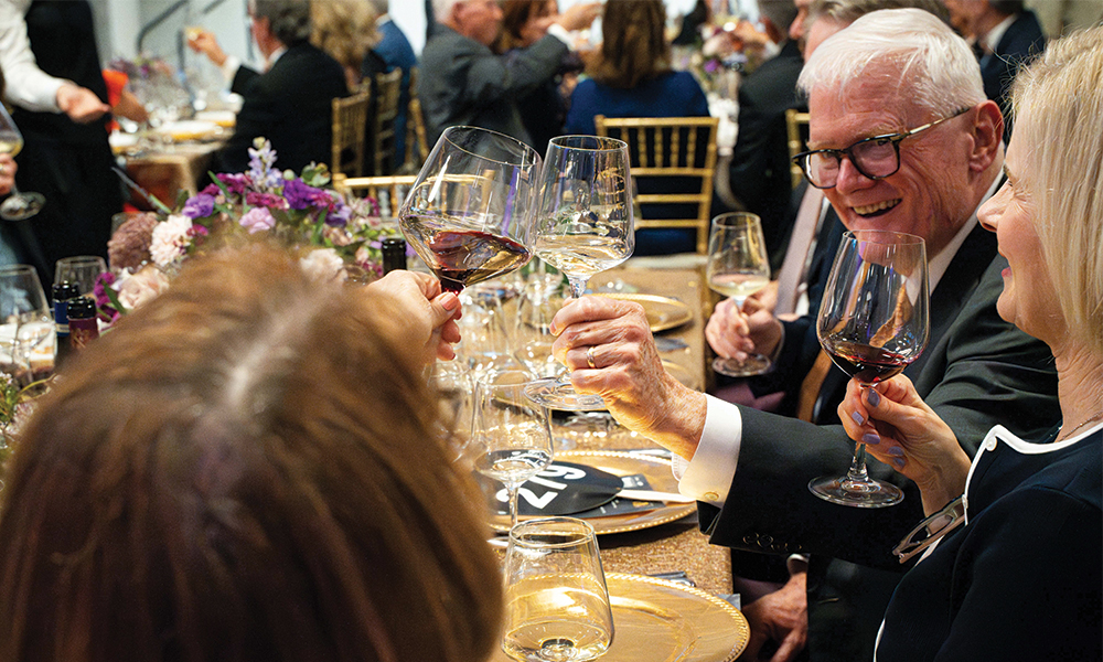 Wine Forum patrons clink their glasses together in a toast.