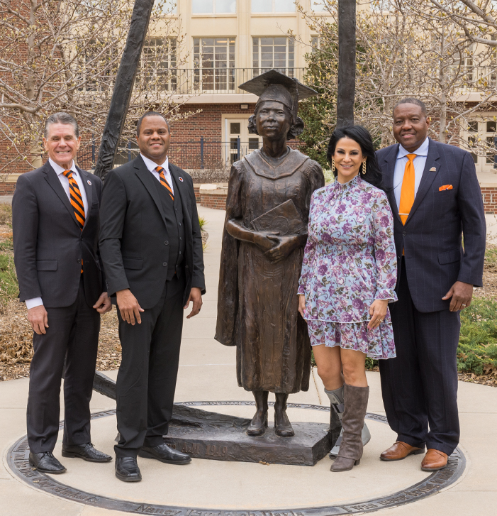 Jon Pedersen, Darius Prier and Renee and Calvin Davis pose at NRD statue on campus