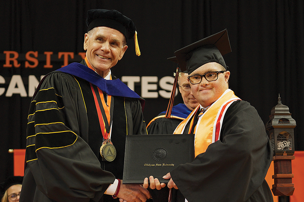 Dean Pedersen shakes hands with a CEHS graduate